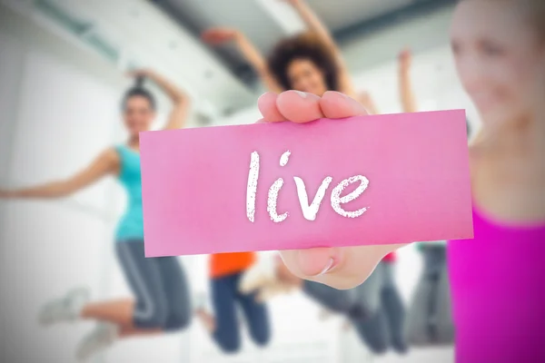 Woman holding pink card saying live — Stock Photo, Image