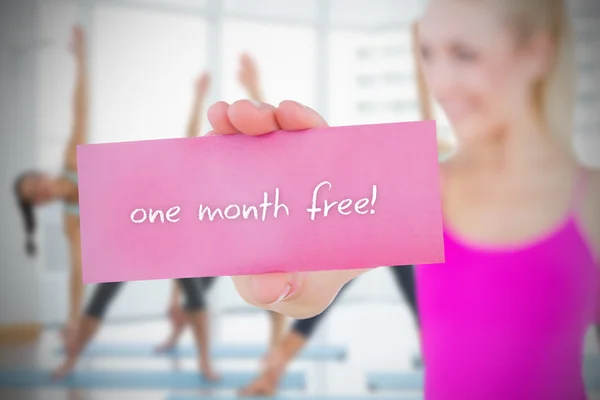 Woman holding pink card saying one month free — Stock Photo, Image