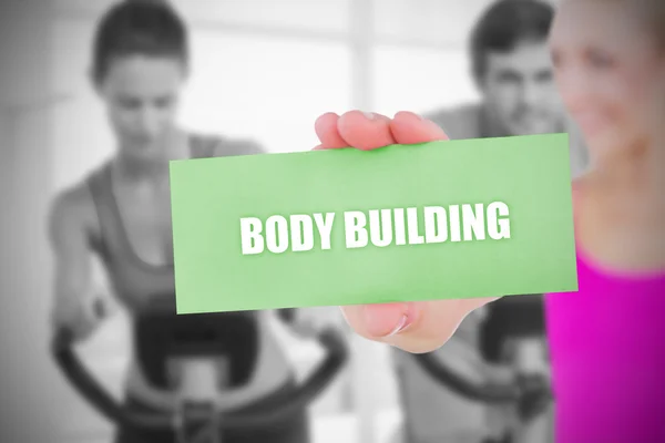 In forma bionda in possesso di carta dicendo body building — Foto Stock