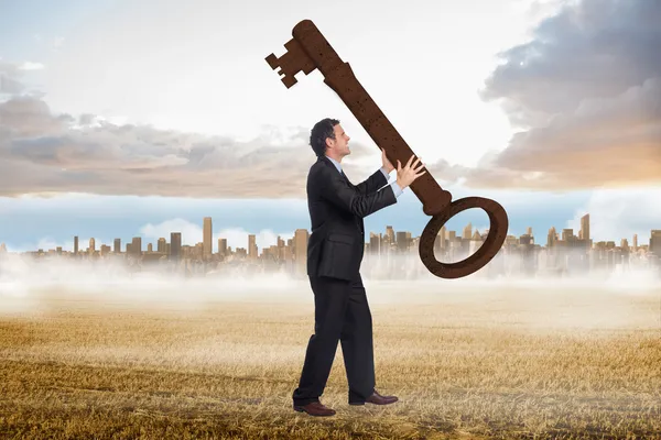 Stressed businessman carrying large key — Stock Photo, Image