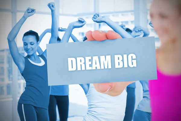 Fit blonde holding card saying dream big — Stock Photo, Image