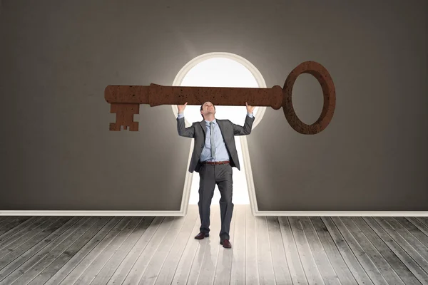 Businessman carrying large key — Stock Photo, Image