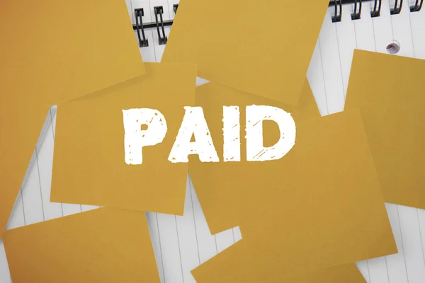 Plătit împotriva hârtiei galbene presărate peste notepad — Fotografie, imagine de stoc