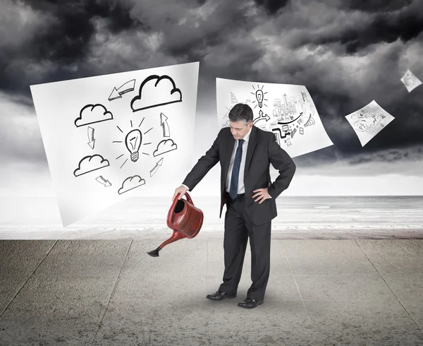 Mature businessman using watering can — Stock Photo, Image