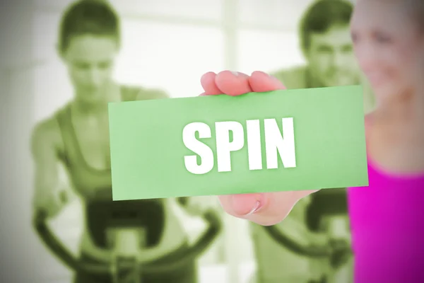 Fit blonde holding card saying spin — Stock Photo, Image