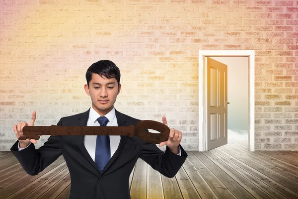 Businessman carrying large key — Stock Photo, Image