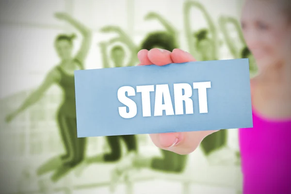 Fit blonde holding card saying start — Stock Photo, Image