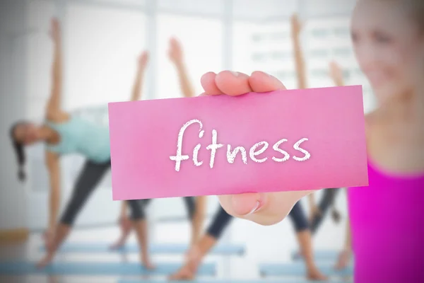 Mulher segurando cartão rosa dizendo fitness — Fotografia de Stock