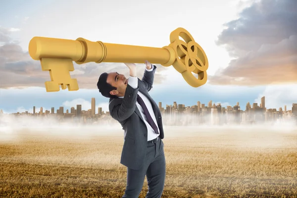 Stressed businessman carrying large key — Stock Photo, Image