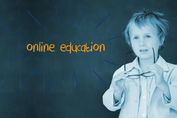 Online education against schoolboy and blackboard — Stock Photo, Image