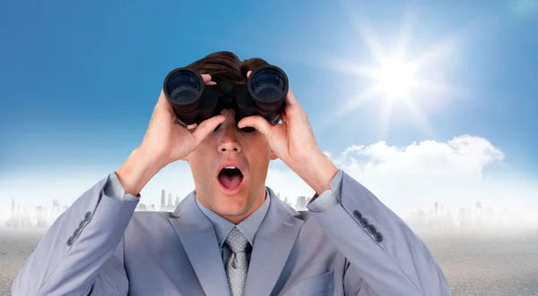 Hombre de negocios sorprendido mirando a través de prismáticos — Foto de Stock