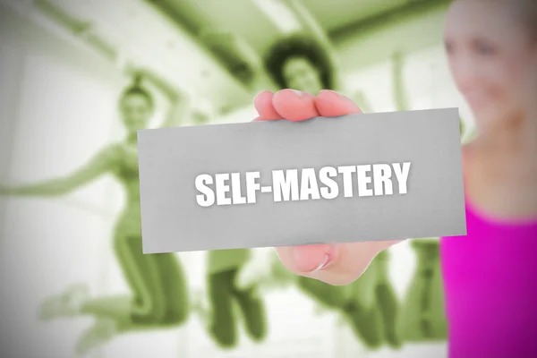 Fit blonde holding card saying self mastery — Stock Photo, Image