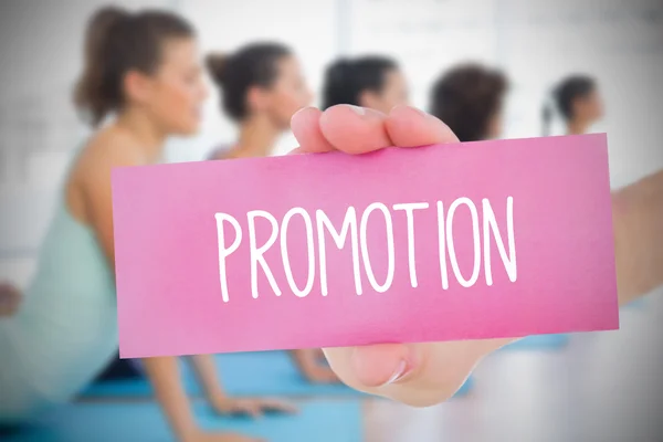 Woman holding pink card saying promotion — Stock Photo, Image