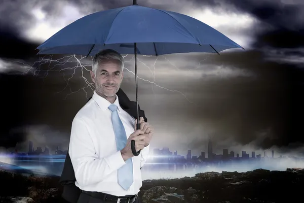 Empresário segurando guarda-chuva azul — Fotografia de Stock