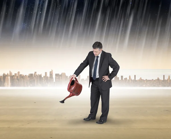 Mature businessman using watering can — Stock Photo, Image