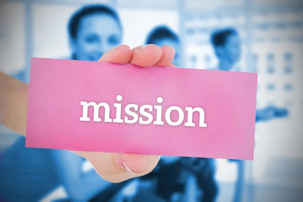 Woman holding pink card saying mission — Stock Photo, Image