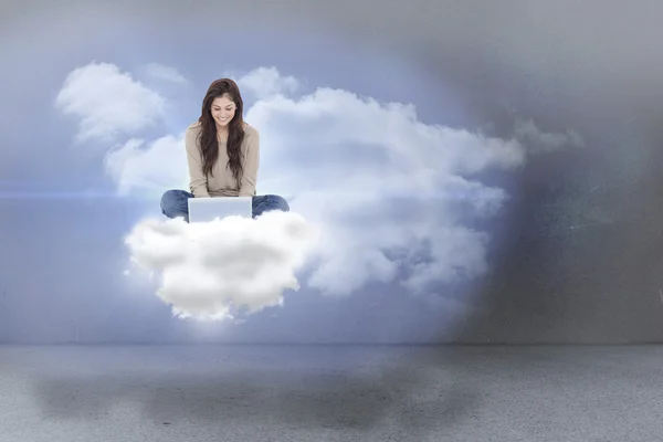 Brunetka siedzi na chmury przy użyciu laptopa — Zdjęcie stockowe