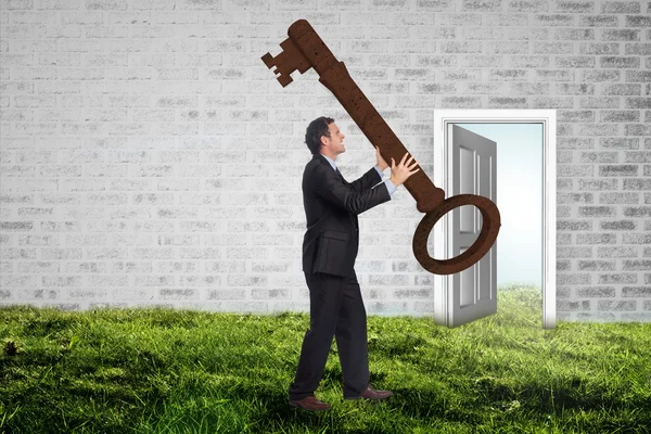 Stressed businessman carrying large key — Stock Photo, Image