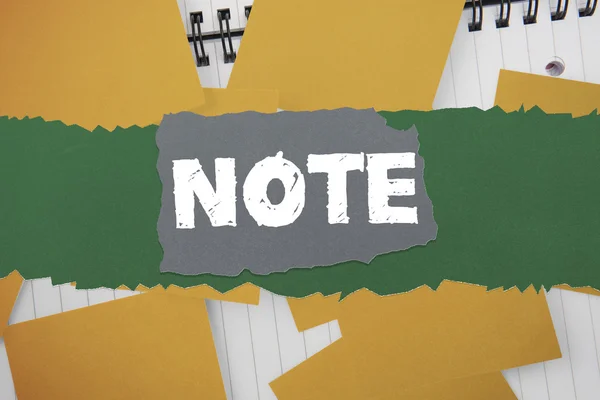 Note against yellow paper strewn over notepad — Stock Photo, Image