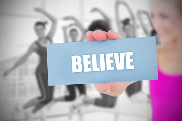 Fit blonde holding card saying believe — Stock Photo, Image