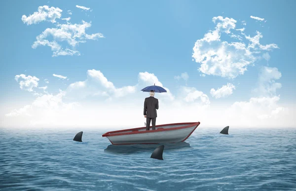 Businessman holding umbrella in a sailboat — Stock Photo, Image