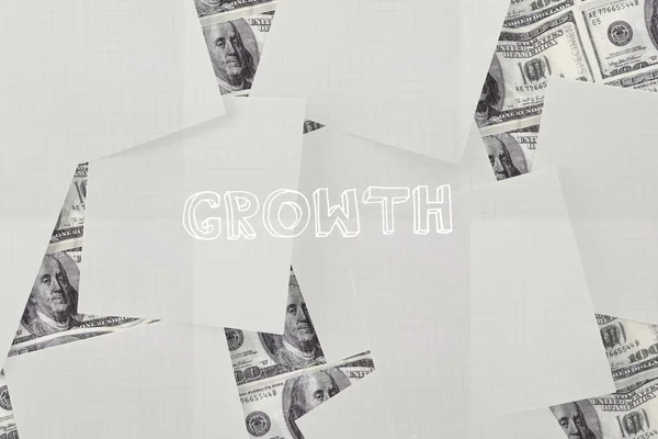 Growth against white paper strewn over dollar bills — Stock Photo, Image
