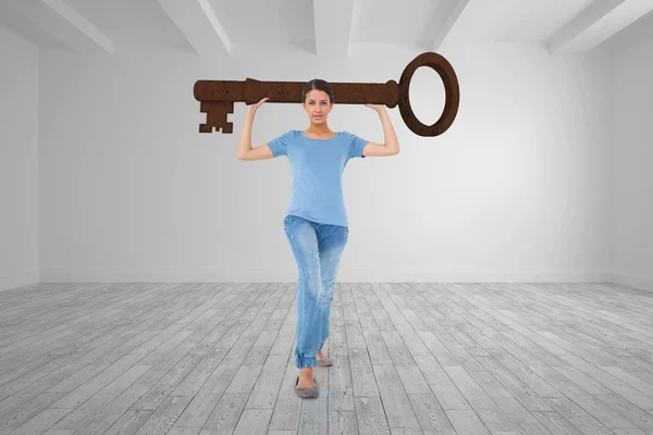 Brunette carrying large key — Stock Photo, Image