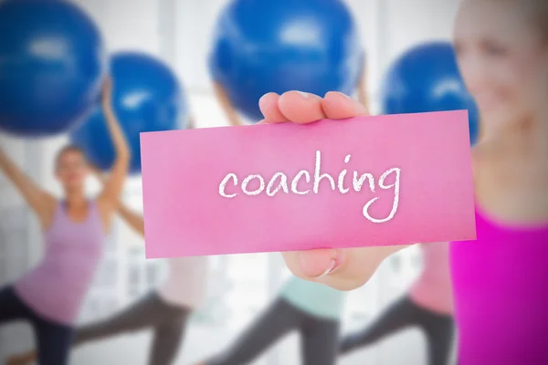 Mujer sosteniendo tarjeta rosa diciendo coaching — Foto de Stock