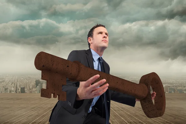 Businessman carrying large key — Stock Photo, Image