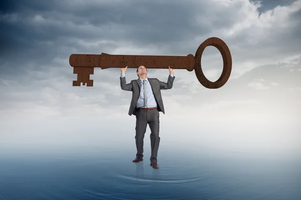 Businessman carrying large key — Stock Photo, Image