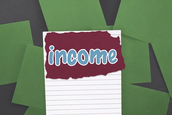 Income against green paper strewn over black — Stock Photo, Image