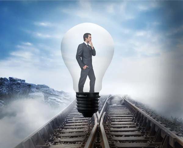 Thinking businessman in light bulb — Stock Photo, Image