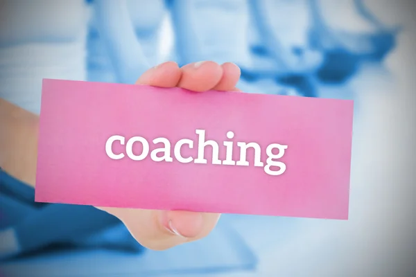 Mulher segurando cartão rosa dizendo coaching — Fotografia de Stock