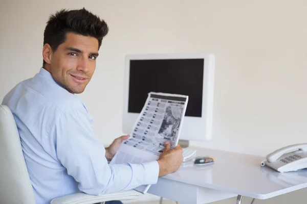 Casual businessman reading newspaper at his desk — Stock Photo, Image