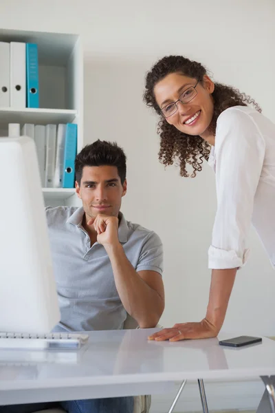 Casual Business Team lächelt gemeinsam in die Kamera am Schreibtisch — Stockfoto