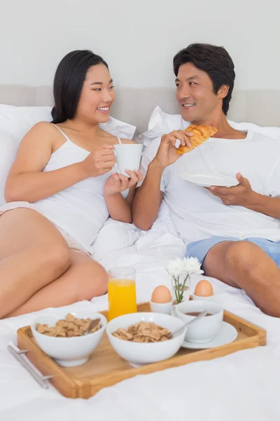 Feliz pareja desayunando en la cama —  Fotos de Stock