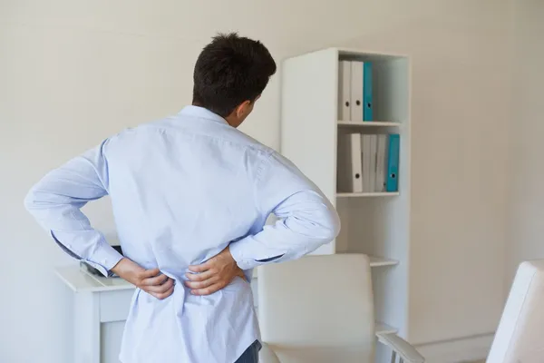 Casual homem de negócios tocando suas costas doloridas — Fotografia de Stock