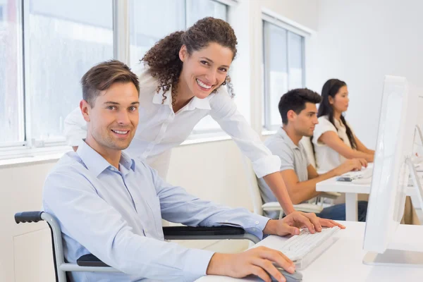 Businessman in wheelchair with colleague — Stock Photo, Image