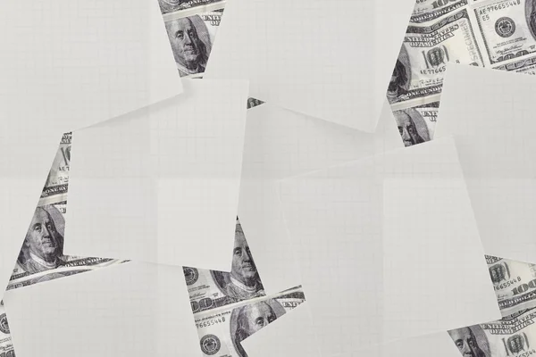 White paper strewn over dollar bills — Stock Photo, Image