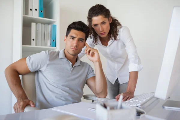 Casual Business Team blickt gemeinsam in die Kamera am Schreibtisch — Stockfoto