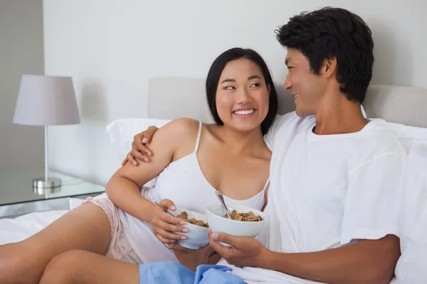 Happy couple having breakfast in bed — Stock Photo, Image