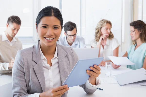 Casual zakenvrouw met behulp van haar Tablet PC tijdens een vergadering — Stockfoto