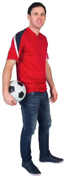 Ventilador de futebol em vermelho segurando bola — Fotografia de Stock