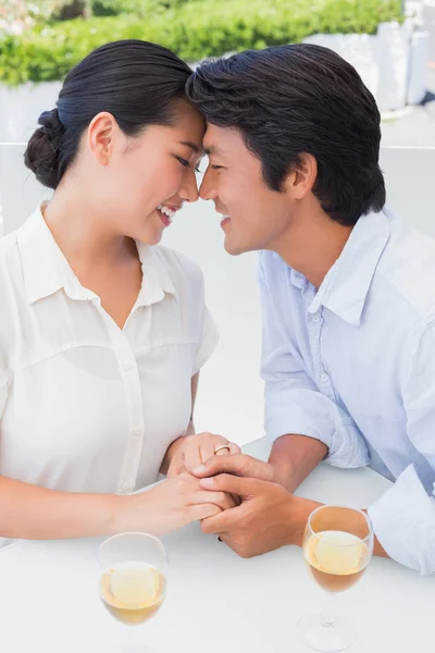 Pareja feliz tomados de la mano y tomando vino blanco —  Fotos de Stock