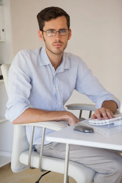 Casual empresário franzindo a testa para a câmera em sua mesa — Fotografia de Stock