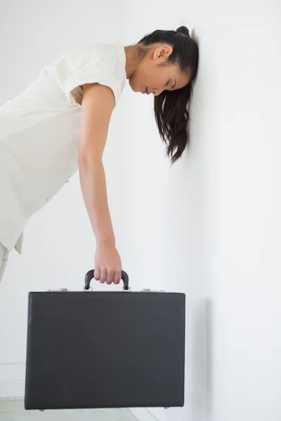 Dorywczo kobieta nachylając się ścianę z teczki — Zdjęcie stockowe