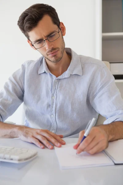Homem de negócios ocasional tomando notas em sua mesa — Fotografia de Stock