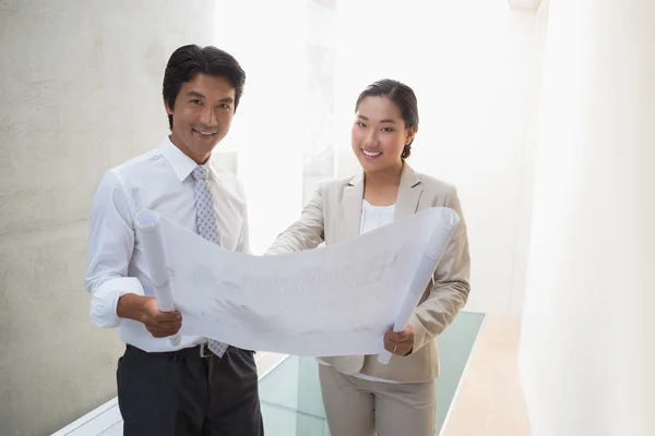 Estate agent looking at blueprint with potential buyer — Stock Photo, Image