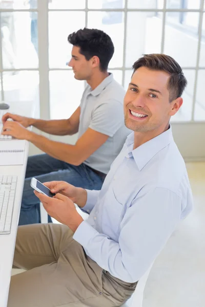 Businessman sending a text at his desk — Stock Photo, Image