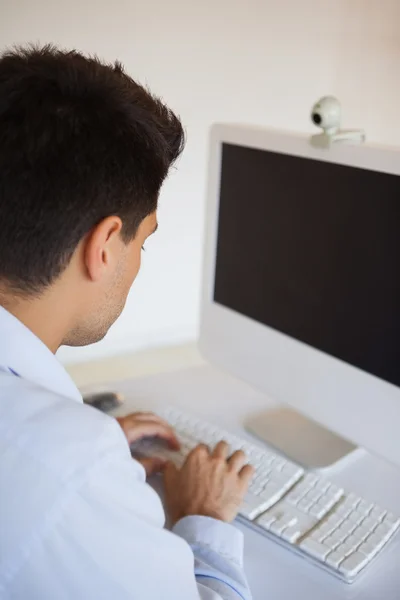 Homme d'affaires occasionnel tapant à son bureau — Photo